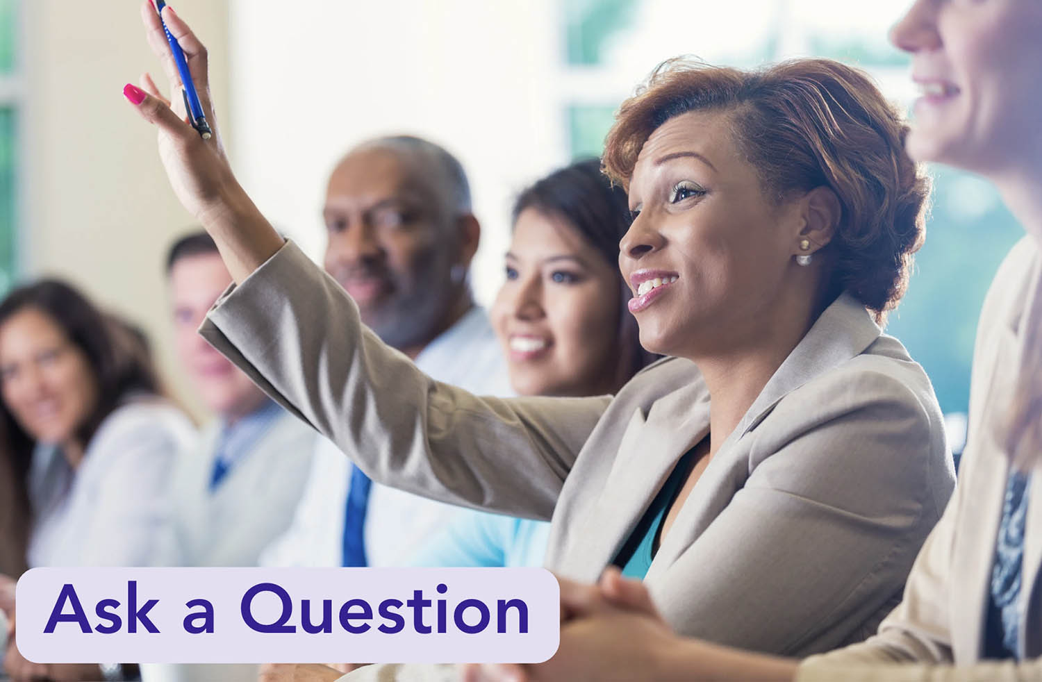 Group of adults looking forward with 1 person raising hand and text, 'Ask a question'