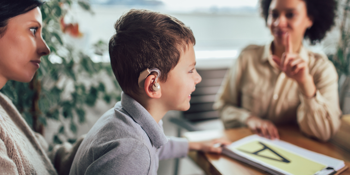 Boy with Hearing Aid Learning Sign Language