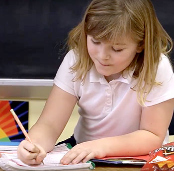 A young girl writing.